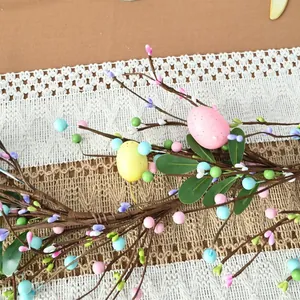 Close-up of Easter egg branch with colorful berries and green leaves on lace runner