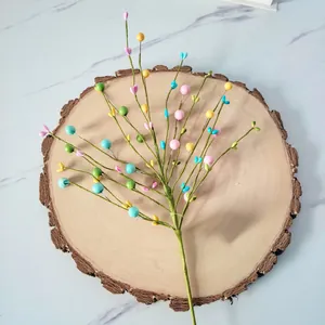 Macro view of colorful foam heart berry branch for home decor on natural wood base
