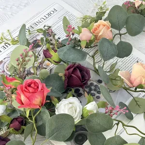 Macro view of artificial rose and eucalyptus vine garland with pink and white flowers