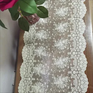 Primer plano del camino de mesa de encaje de algodón bordado 3D blanco en madera
