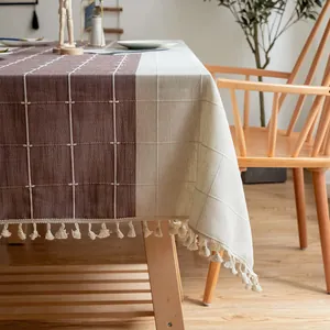 Detailaufnahme einer minimalistischen bestickten karierten Tischdecke mit beigen Quasten.