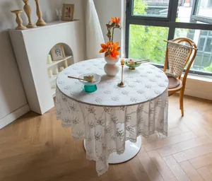 Élégante nappe vintage française en dentelle blanche brodée sur une table à manger