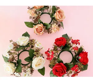 Three assorted artificial rose candle ring wreaths in peach, white, and red.
