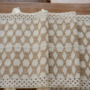 Close-up view of woven cotton linen table runner with tassel and diamond pattern detail.