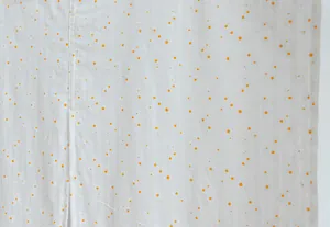 Close-up of white striped fabric door curtain with delicate orange floral print details