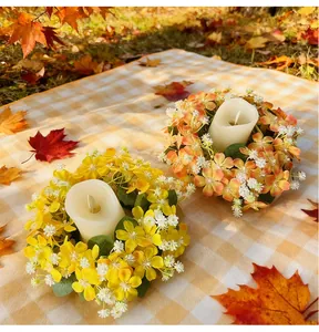 Ghirlande di candele ai fiori selvatici autunnali su una tovaglia da picnic