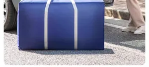 Durable blue large capacity moving storage bag for clothes and quilts on outdoor pavement.