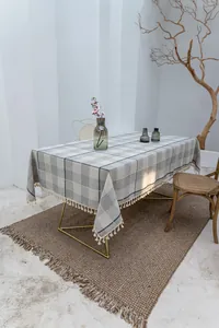 Detailansicht einer grau karierten Baumwoll-Leinen-Tischdecke mit eleganten Quasten