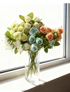 Detailed view of mixed color artificial roses in a clear glass vase on a windowsill