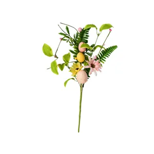 Vue macro d'une branche de Pâques artificielle avec œufs tachetés et fleurs colorées