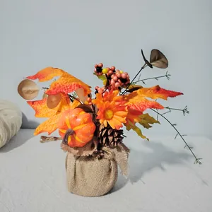 Detailed view of harvest festival pumpkin arrangement with maple leaves and burlap base