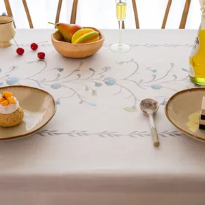 Detailed macro view of elegant floral embroidered linen tablecloth on a dining table