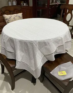 Close-up view of a high-end white French lace tablecloth featuring elegant floral embroidery