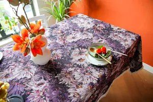 Detail view of purple floral jacquard tablecloth on a dining table with props