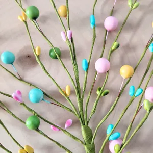 Close-up of colorful foam berry branches for festive home decor and window displays.