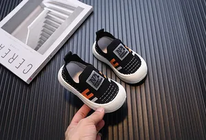 Close-up detail of breathable fly-knit children's sneakers with soft white soles.