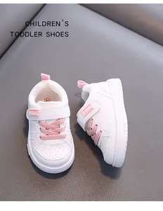 Close-up view of toddler walking shoes in white microfibre leather with pink accents