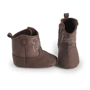 Détail de bottes de cowboy marron pour bébé avec semelles souples et broderies blanches
