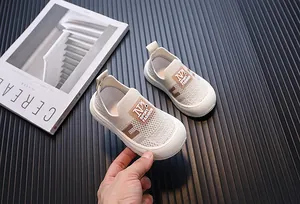 Close-up of breathable knit children's sneakers featuring soft soles in a beige color