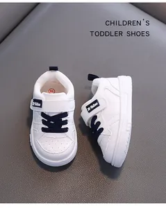 Detailed view of white toddler sneakers with blue laces and microfiber leather.