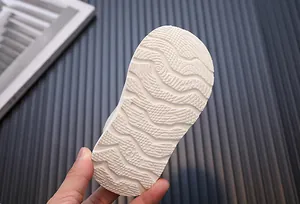 Close-up of the white non-slip wavy textured sole on a children's soft casual shoe