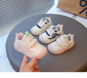 Dettaglio delle scarpe primi passi per neonati con carini motivi a fragola e polizia