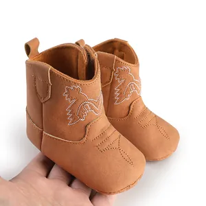 Détail de chaussures de marche bébé style cowboy en daim marron avec semelle souple