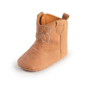 Gros plan sur une botte de cowboy pour bébé avec texture suédée et broderie