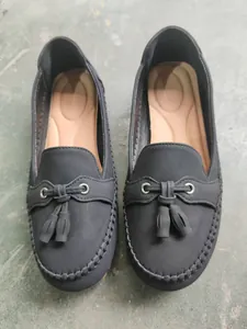Detailed close-up of dark grey women's tassel loafers featuring a comfortable slip-on design.