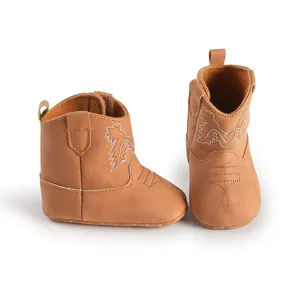 Vue de face et de profil de bottes de cowboy pour bébé en daim marron