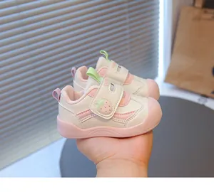 Primo piano di scarpe da camminata per neonati rosa e bianche con motivo a fragola