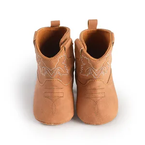 Vue de face de bottes de cowboy marron pour bébé avec semelles souples et broderies