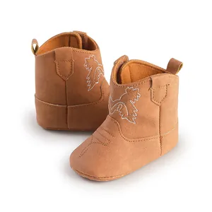 Détail de bottes de cowboy pour bébé en daim marron avec semelle souple et broderie