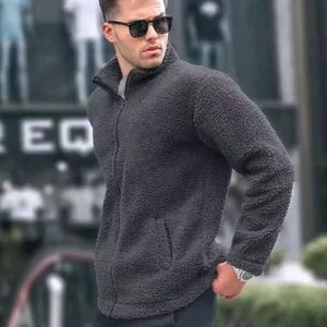 Detailed macro view of dark grey sherpa fleece jacket texture and high collar style on model