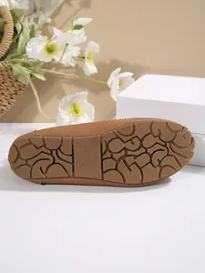 Detailed macro view of the non-slip rubber sole of a brown women's loafer