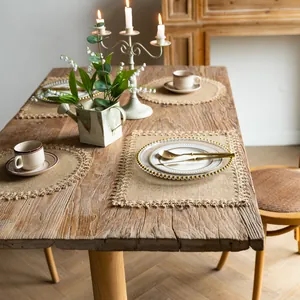 Farmhouse style vintage jute placemats with decorative fringe on a rustic wooden table