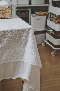 Macro view of high-quality French white embroidered lace tablecloth with floral patterns