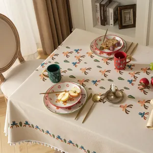 Elegante tovaglia jacquard natalizia con motivi di renne e bordo con frange di pompon bianchi