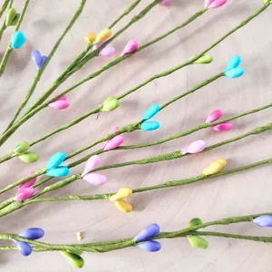Close-up detail of colorful heart-shaped foam berries on green decorative artificial twigs