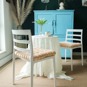 Detail view of thick biscuit-shaped plush chair cushions in a home setting