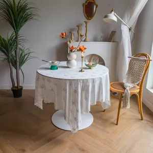 Nappe vintage française en dentelle blanche avec broderie florale dans un salon chic