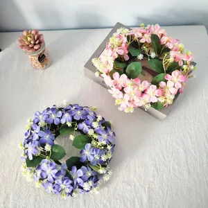 Top view of pink and purple artificial wildflower candle ring wreaths for home decor