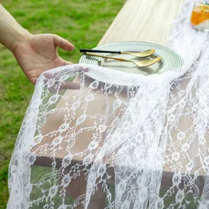 Gros plan sur un tissu en dentelle blanche à fleurs utilisé comme chemin de table
