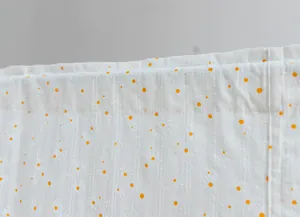 Close-up detail of white striped fabric door curtain with small yellow daisy pattern