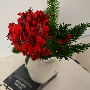 Close-up of red artificial Christmas poinsettia bouquet with pine branches in white vase