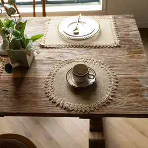 Macro view of rustic jute placemats with elegant tassel edges on a vintage wooden table