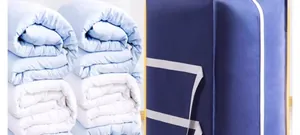 Large capacity blue storage bag for quilts and clothes shown next to folded bedding