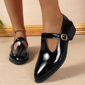 Close-up of retro black patent leather Mary Jane shoes with pointed toe and buckle