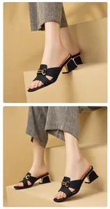 Detailansicht französischer schwarzer Sandalen mit einer eleganten goldenen C-Schnalle