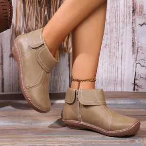 Stylish women's brown faux leather ankle boots with stitching details and a side zipper.
